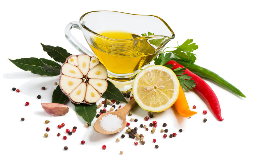 Olive oil surrounded with fruits and herbs